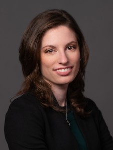 Headshot of website author - a light-skinned woman with shoulder-length brown hair wearing a black blazer